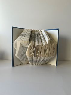 an open book with folded pages that spell out the word love