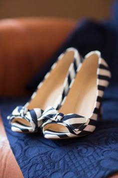 a pair of black and white striped high heels on a blue quilted bed sheet