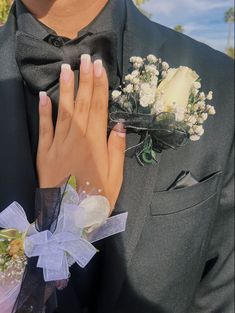 a close up of a person wearing a suit and tie with flowers on his lapel