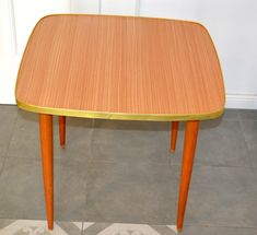 a wooden table sitting on top of a tiled floor