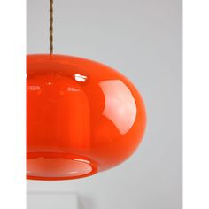 an orange light hanging from a white ceiling