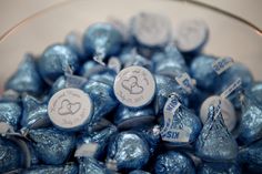 blue candy candies in a glass bowl with white tags on the top and silver foil wrapped around them