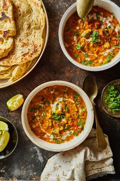 two bowls of soup with tortillas and limes on the side, next to each other