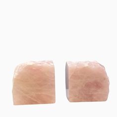 two square pink stones sitting on top of each other in front of a white background