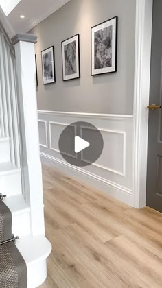 an empty room with pictures on the wall and stairs leading up to it's entrance