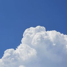 the plane is flying high in the blue sky with white clouds behind it and an airplane on the right side