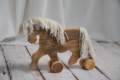 a wooden toy horse with fringes on it