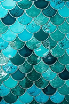 a close up view of the scales of a blue fish scale pattern on a wall