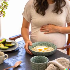 a pregnant woman standing in front of a bowl of eggs and avocado on a table