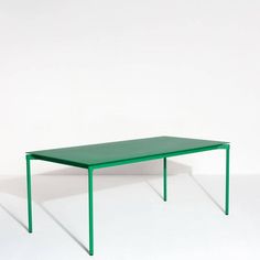 a green table sitting on top of a white floor