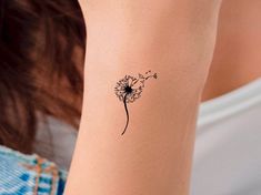 a dandelion tattoo on the wrist is shown in black ink, and it looks like