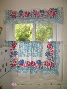 a kitchen with a white stove top oven sitting next to a window covered in blue and red flowers