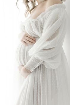 a woman in a white dress is posing for the camera with her hands on her hips