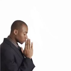 a man in a suit is praying with his hands together