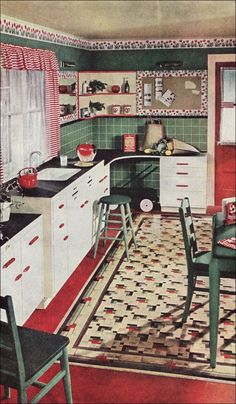 an old fashioned kitchen with green walls and red flooring, white cabinets and black counter tops