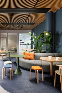 an office lounge area with round tables and couches