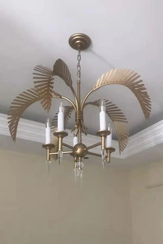 a chandelier hanging from the ceiling in a room with beige walls and white trim