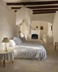 a bed room with a neatly made bed and a fireplace