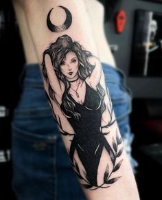 a woman's arm with a tattoo on it and a half moon behind her