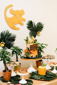 a table topped with cakes and desserts covered in jungle animals on top of it