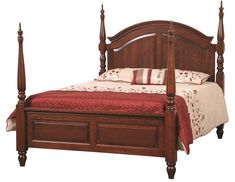 a wooden bed with four posts and red bedspread