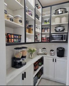 a kitchen with white cabinets and open shelving