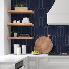 a kitchen with blue hexagonal tiles and wooden cutting board on the counter top