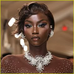 a model wears an elaborate necklace and earrings