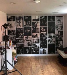 a room with many black and white pictures on the wall behind a camera set up in front of it