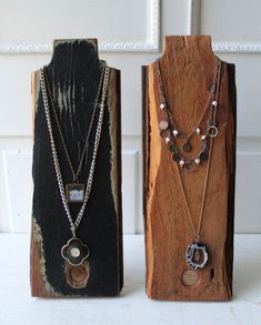 two pieces of wood with necklaces on them