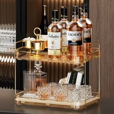 a bar cart with liquor bottles and glasses on the top shelf next to each other