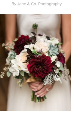 a bride holding a bouquet of red and white flowers