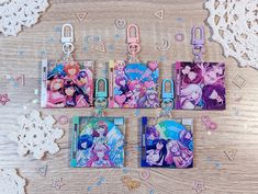 four anime themed binders and clip holders on a wooden table with lace doily