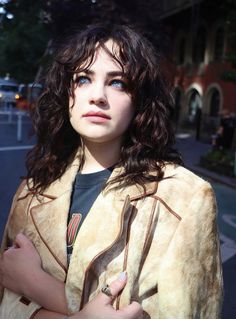 a woman standing on the street with her arms crossed