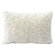 a white pillow that is made out of wool and has a long pile of fur on it