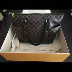 Authentic, Sold Out And Highly Coveted Totally Mm. Brand New With Original Box, Dust Bag And Receipt. Never Worn... Decided To Sell. Tan And Ebony Damier Ebene Coated Canvas Louis Vuitton Totally Mm With Brass Hardware, Tonal Ebene Leather Trim, Dual Flat Shoulder Straps, Dual Exterior Slip Pockets At Sides, Red Canvas Lining, Three Slit Pockets At Interior Walls And Zip Closure At Top. Includes Dust Bag. Details Shoulder Strap Drop: 9.5" Height: 12" Width: 13" Depth: 5.5" Lv Favorite Mm, Louis Vuitton Totally Mm, Marmont Super Mini, Lv Bumbag, Lv Neonoe, Small Canvas Bags, Louis Vuitton Totally, Gucci Padlock, Favorite Mm