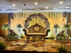 an elaborately decorated stage set up with flowers and greenery