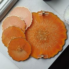 three orange plates sitting on top of a table next to a vase and flower pot