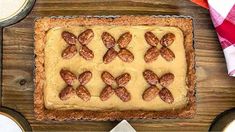 a cake with frosting and bows on it sitting on top of a wooden table