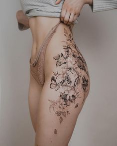 a woman is showing off her thigh with flowers on it