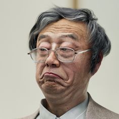 an old man wearing glasses and a suit looks at the camera while he is frowning