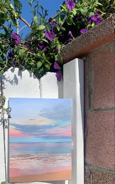 a painting is hanging on the side of a wall next to some plants and flowers