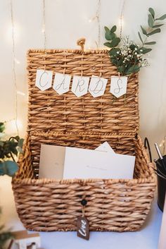 a wicker basket filled with cards and envelopes next to a christmas ornament