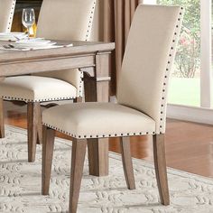 a dining room table and chairs in front of a fireplace with a rug on the floor