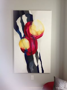 an abstract painting hangs on the wall above a bed in a room with white walls