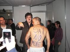 two men standing next to each other with writing on their backs