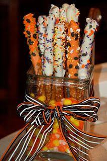 a glass vase filled with candy canes and sprinkles on top of a table