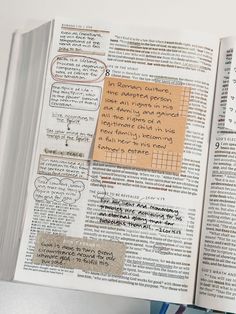 an open book with writing on it and sticky notes attached to the pages that have been altered