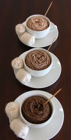 three white bowls filled with hot chocolate and marshmallows