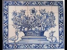 a blue and white tile with flowers in a vase